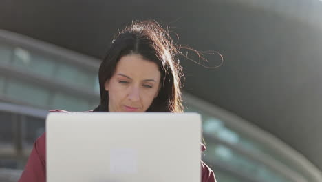 Thoughtful-beautiful-mature-woman-working-with-laptop-outdoor